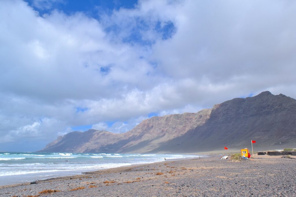 La spiaggia di Famara: scogliere erose dal vento e surfisti